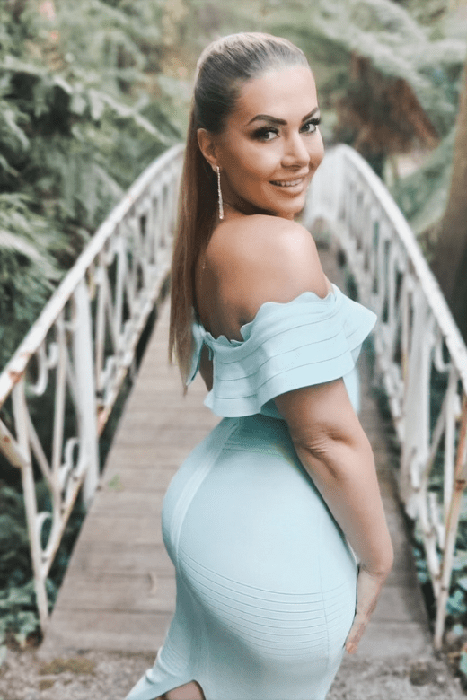 Woman wearing a figure flattering Billie Bandage Midi Dress - Dusty Pink Bodycon Collection