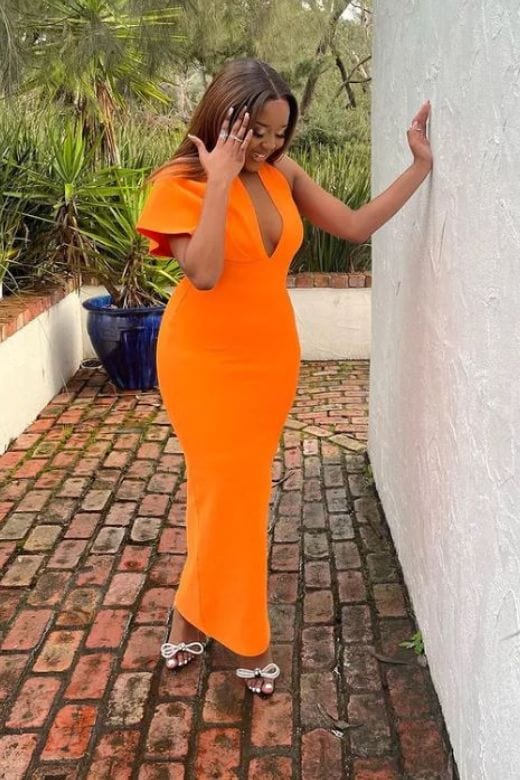 Woman wearing a figure flattering Blake Bandage Maxi Dress - Apricot Orange BODYCON COLLECTION