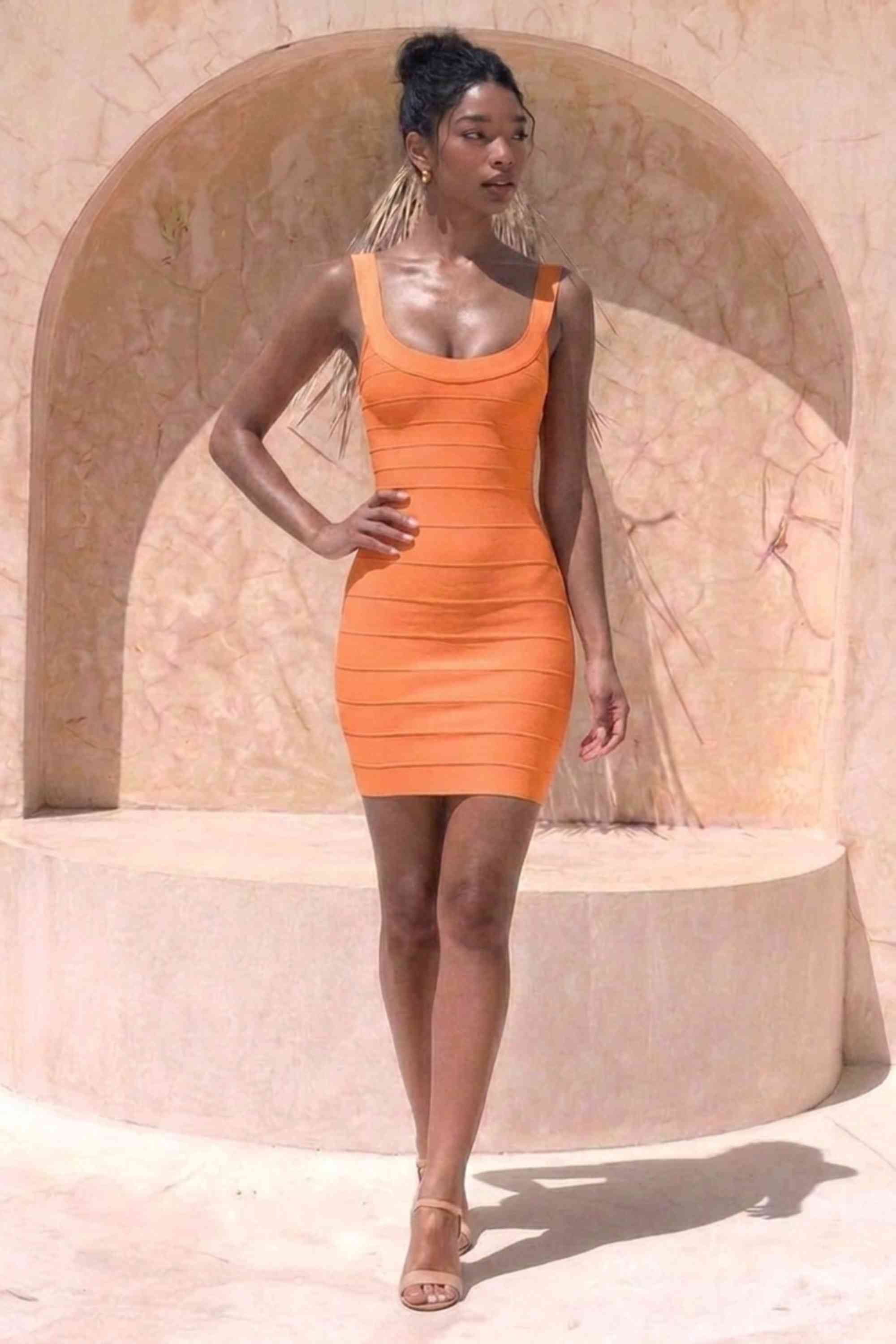 Woman wearing a figure flattering Cindy Bandage Mini Dress - Apricot Orange BODYCON COLLECTION Pty Ltd