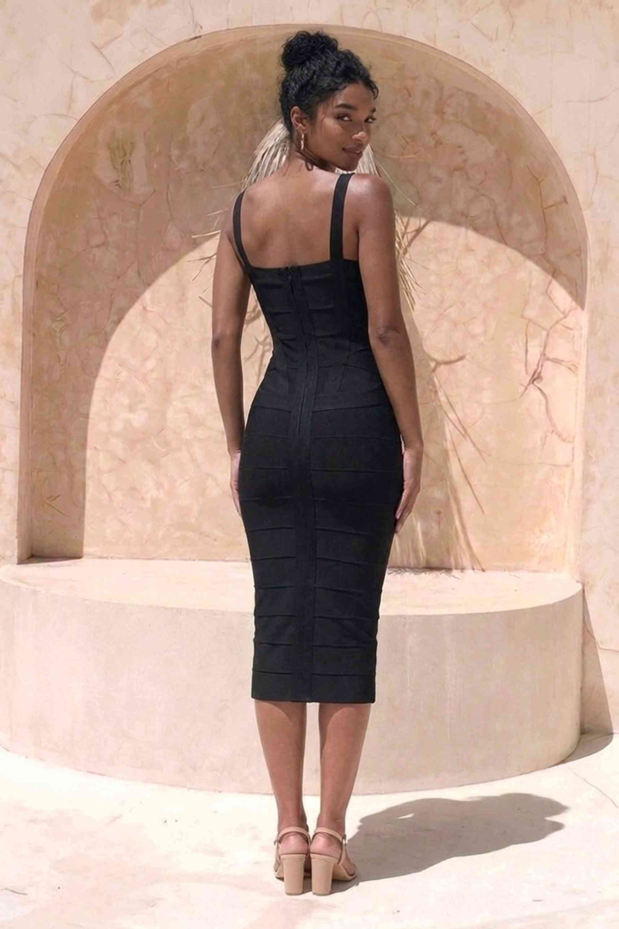 Woman wearing a figure flattering black party dress Heidi Bandage Midi Dress - Classic Black Bodycon Collection