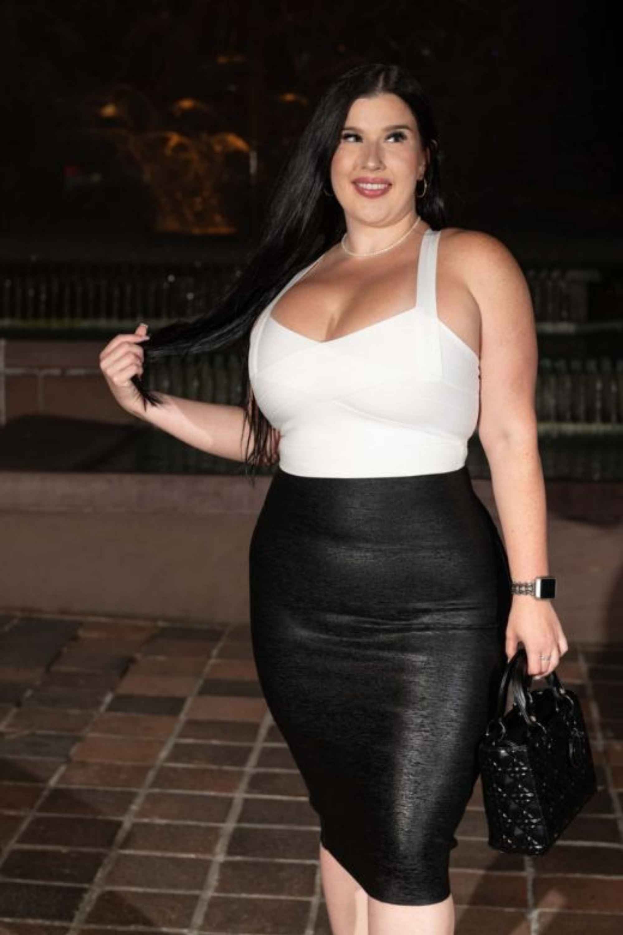 Woman wearing a figure flattering High Waist Leather Pencil Skirt Midi Length - Metallic Black BODYCON COLLECTION