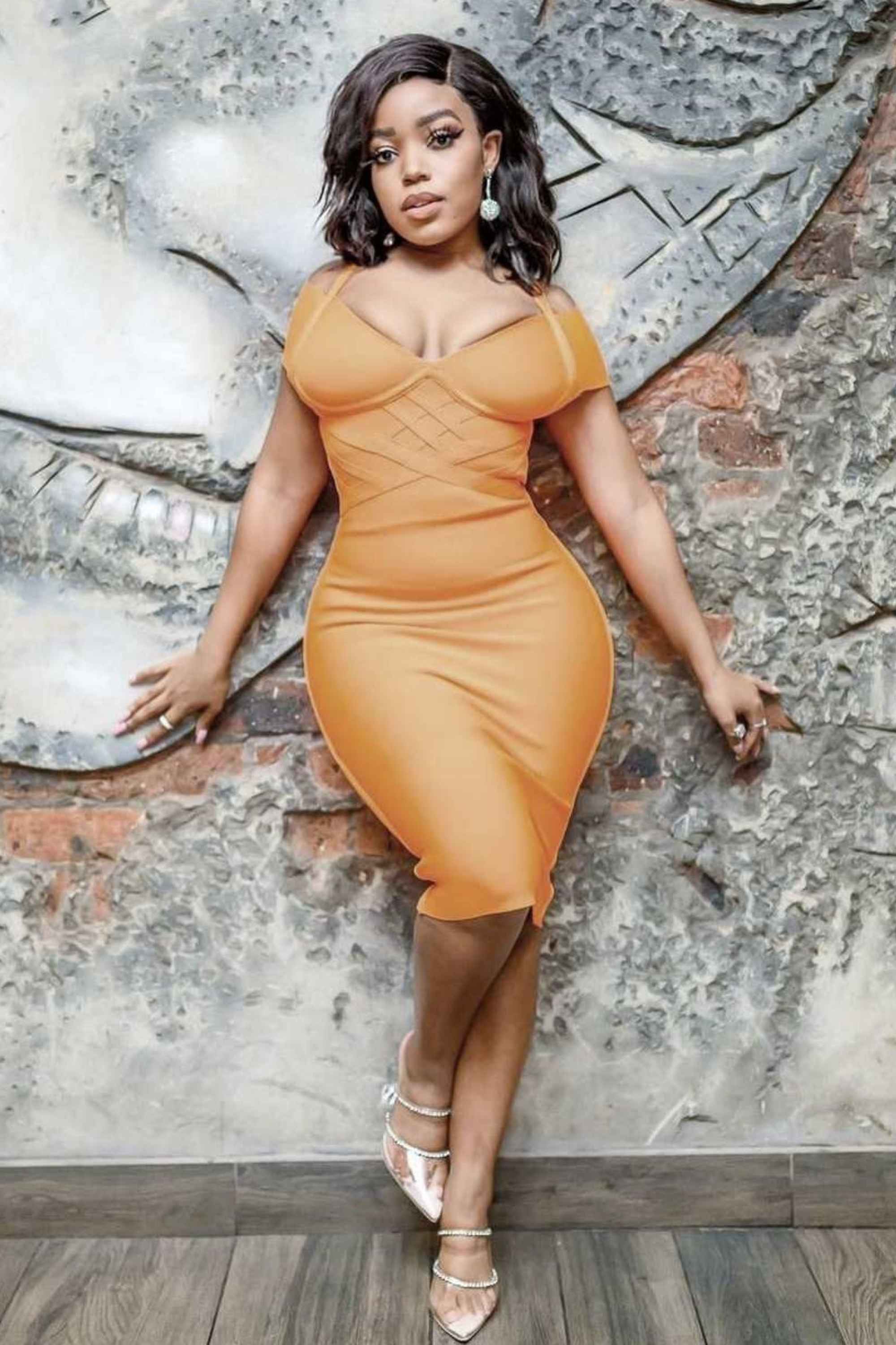 Woman wearing a figure flattering Leo Bandage Dress - Apricot Orange Bodycon Collection