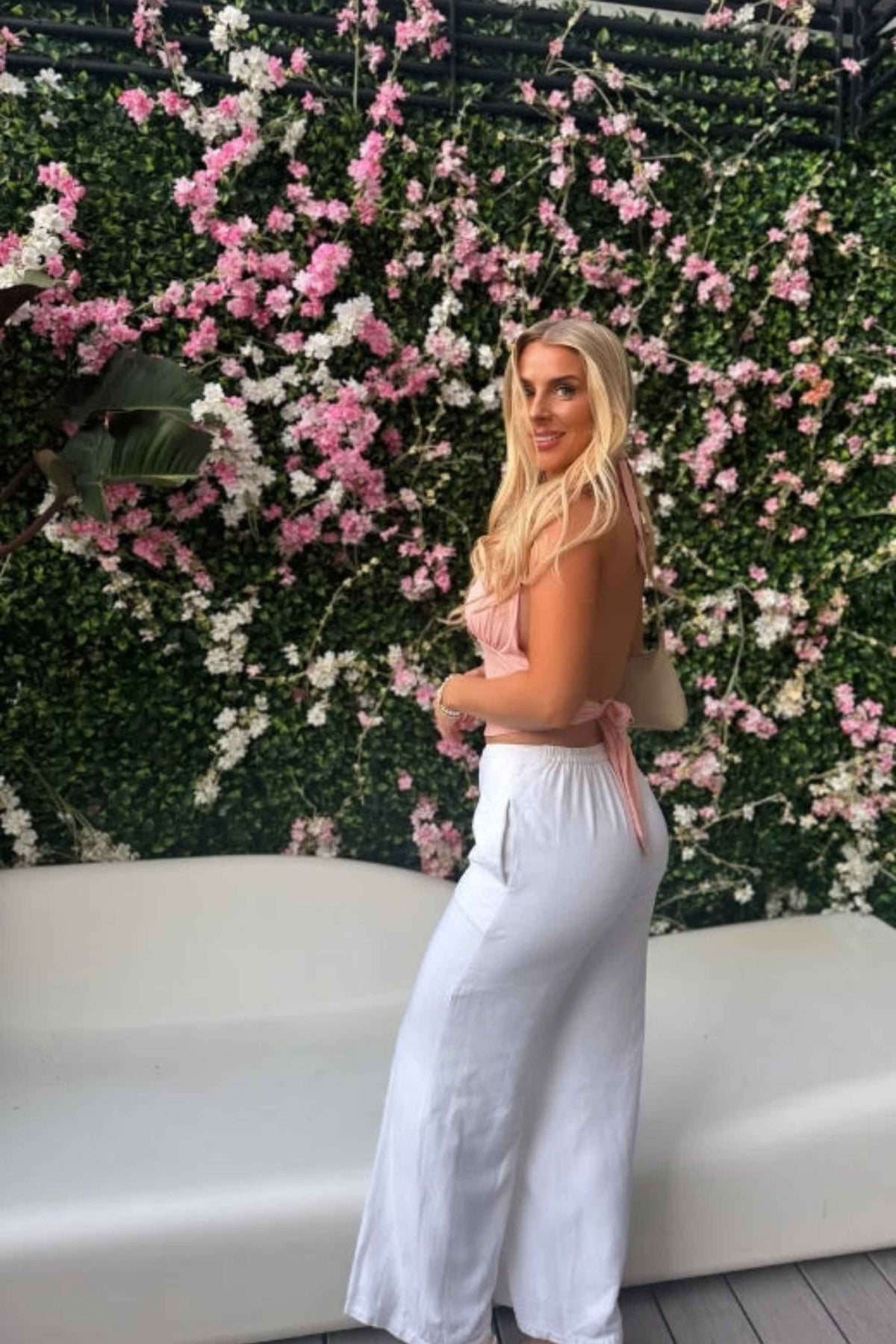 Woman wearing a figure flattering  Aby Halter Top - Pink Peach Fuzz BODYCON COLLECTION Pty Ltd