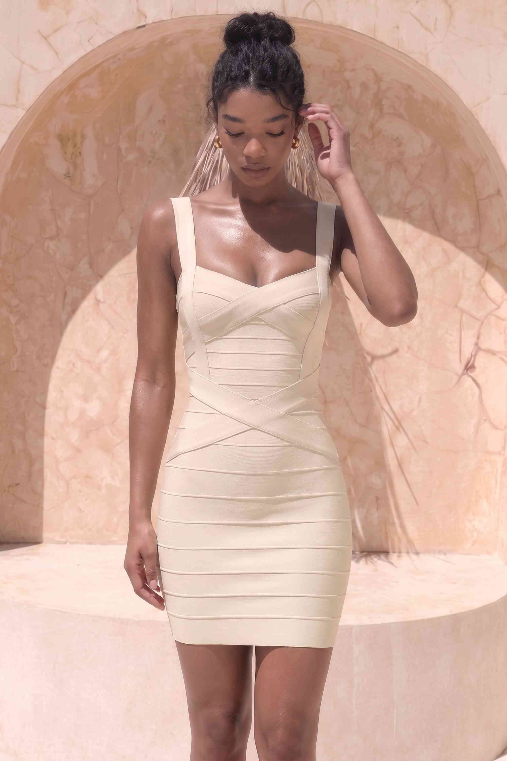 Woman wearing a figure flattering  Heidi Bandage Mini Dress - Cream Bodycon Collection