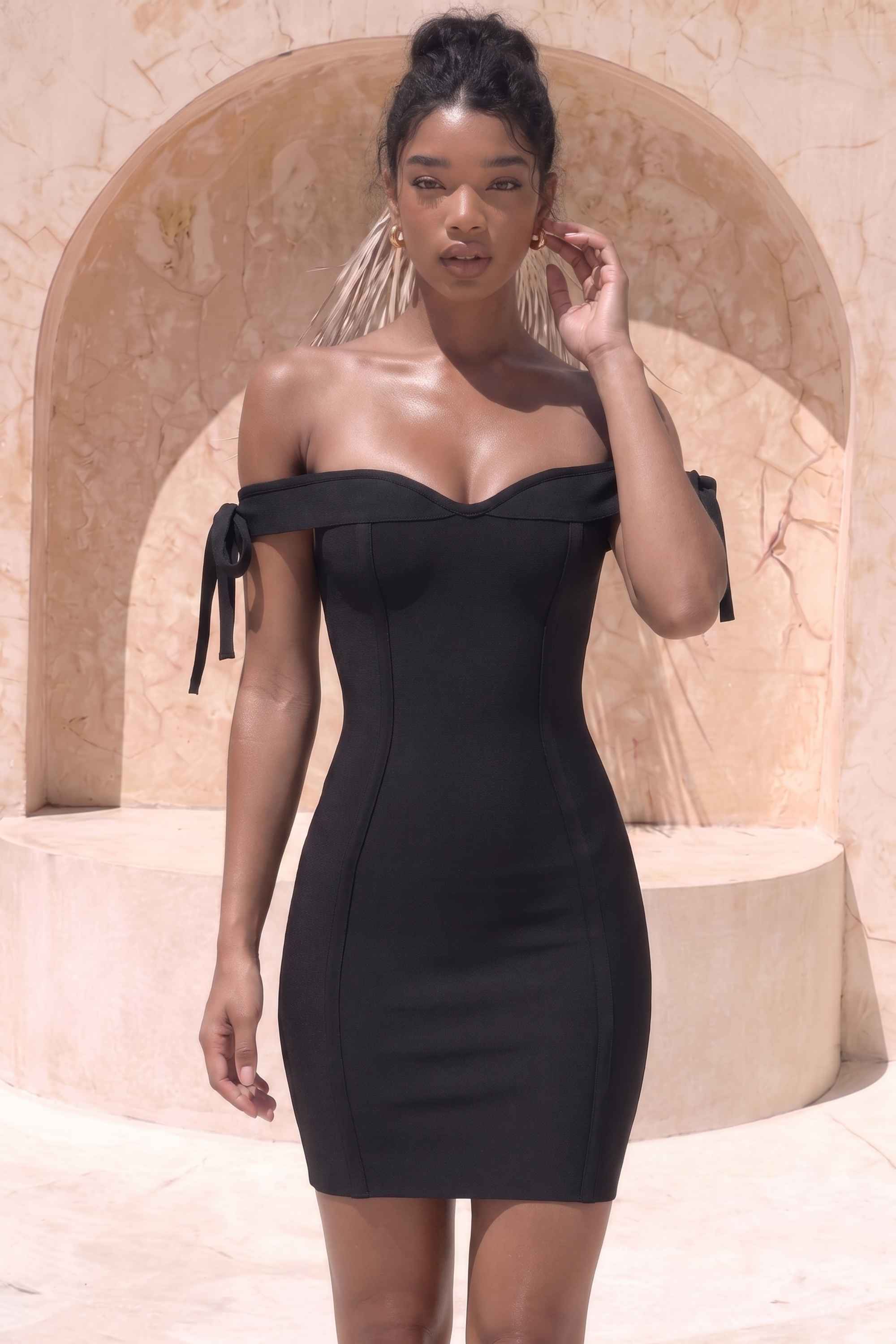 Woman wearing a figure flattering  Penelope Bandage Mini Dress - Classic Black BODYCON COLLECTION
